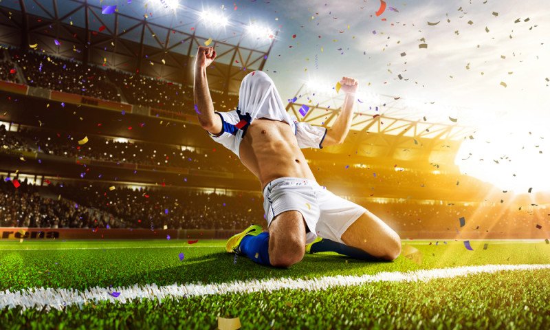 Soccer player in action on night stadium panorama background