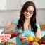 Happy young woman pouring vegetable smoothies