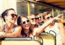 Grupo de amigos sonrientes que viajan en un autobús turístico